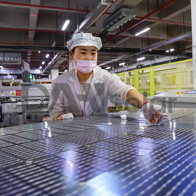 Workers in DAH Solar's smart photovoltaic production workshop inspect the cell layout.
